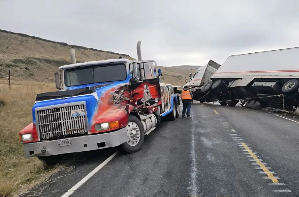 A Jacks Towing Heavy Duty Wrecker winching a rolled over tractor trailer on highway in Pasco Washington