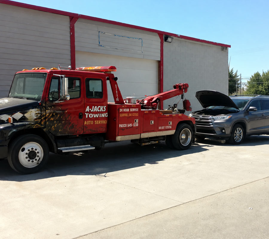 A-Jacks Tow Truck Operator providing a jump start in a parking lot in Pasco Washington