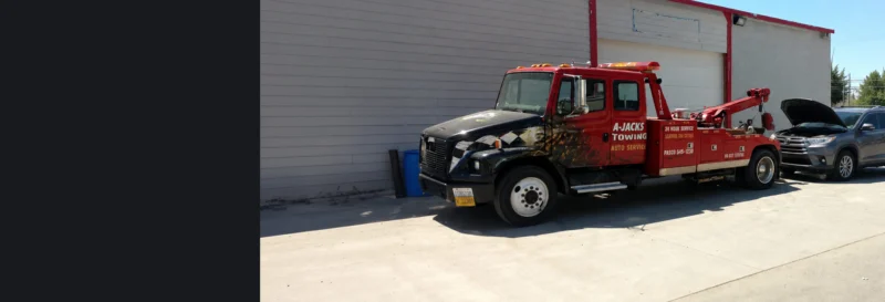 Roadside assistance A-Jacks Towing Pasco Washington Tow Truck In front of SUV Providing a jump start service